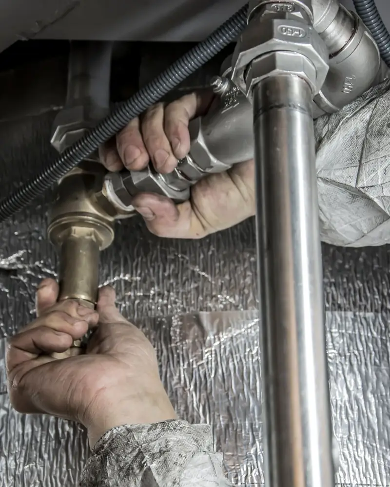 Plumber repairing a pipe with a wrench